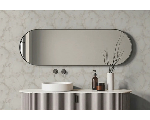 Ovale badkamerspiegel boven een witte opzetwastafel en geribbeld badmeubel voor een wand met marmerlook.