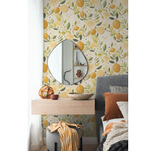 Vliesbehang met citroenpatroon in een slaapkamer met organische spiegel, zwevend nachtkastje en grijs gestoffeerd bed.