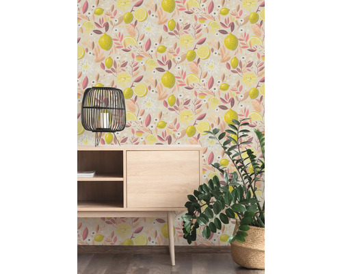 Vliesbehang met citroen- en bloemenpatroon in een kamer met houten dressoir, zwarte lantaarn en een groene plant.