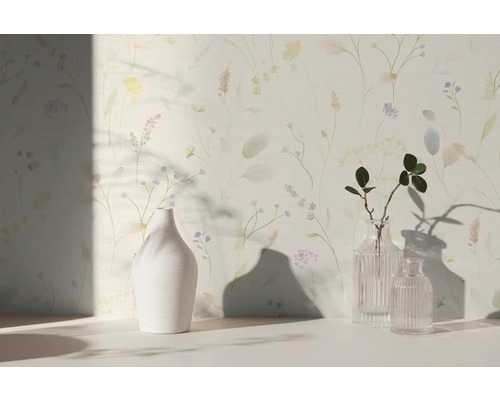 Vliesbehang met fijn floraal patroon van grassen en bloemen in aquarelstijl, gecombineerd met vazen in een lichte kamer.