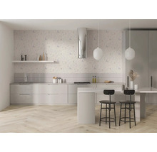 Moderne lichte keuken met bloemen vliesbehang op de muur, lichte keukenkasten, kookeiland met barkrukken en een visgraat parketvloer.