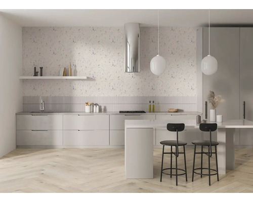 Moderne lichte keuken met bloemen vliesbehang op de muur, lichte keukenkasten, kookeiland met barkrukken en een visgraat parketvloer.