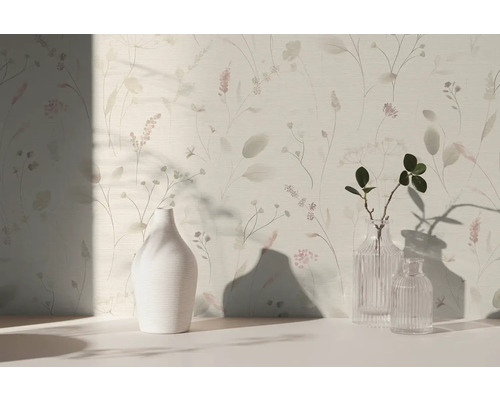 Licht behang met verfijnd bloemenpatroon en grassen, met daarvoor een witte keramieken vaas en twee glazen vazen op een licht oppervlak.