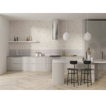 Lichte, moderne keuken met bloemenbehang, lichte houten visgraatvloer, witte kasten, kookeiland, zwarte barkrukken en ronde hanglampen.