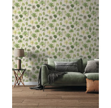 Moderne woonkamer met behang met palmboommotief, een groene bank met kussens, een bijzettafel met lamp en een houten vloer.