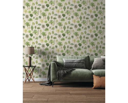 Moderne woonkamer met behang met palmboommotief, een groene bank met kussens, een bijzettafel met lamp en een houten vloer.