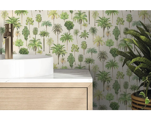 Vliesbehang met palmboommotieven in een lichte badkamer achter een witte wastafel en een houten onderkast.