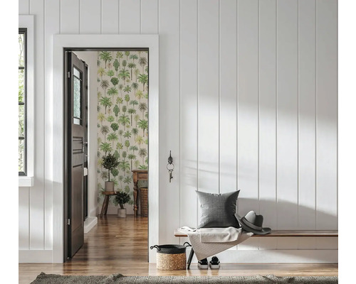 Lichte gang met witte houten lambrisering, houten bank met kussen en hoed en zicht door een deur op een kamer met palmboombehang.