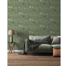 Behang met palmbomenpatroon in een woonkamer met een groene bank, bijzettafel en houten vloer.