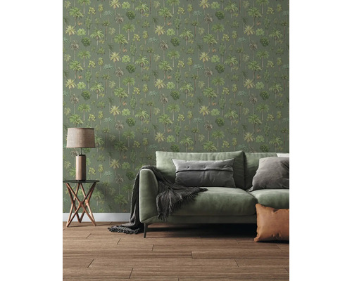 Behang met palmbomenpatroon in een woonkamer met een groene bank, bijzettafel en houten vloer.