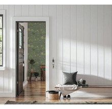 Hal met witte houten wandpanelen, houten bank en een open deur naar een kamer met groen behang met palmboommotief.