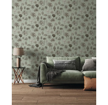 Vliesbehang met palmenpatroon in een lichte woonkamer met groene bank en houten vloer.