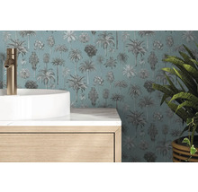 Behang met palmboompatroon achter een witte waskom met goudkleurige kraan en een houten onderkast in een moderne badkamer.