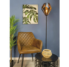 Woonkamer scène met fauteuil, vloerlamp, tafel en muurschildering