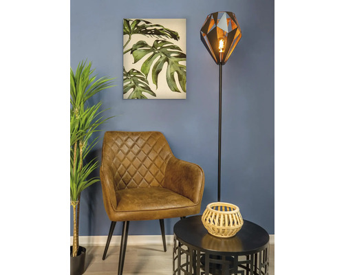 Woonkamer scène met fauteuil, vloerlamp, tafel en muurschildering