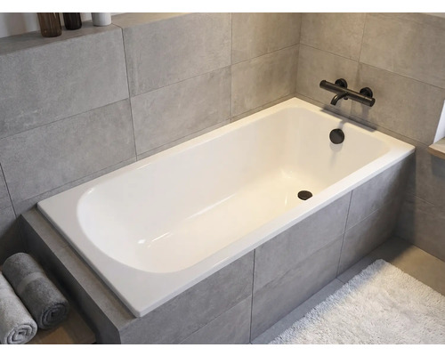 Ingebouwd bad in badkamer met kraan en handdoeken