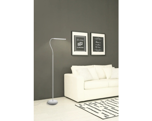 Staande lamp in een woonkamer met bank en foto's