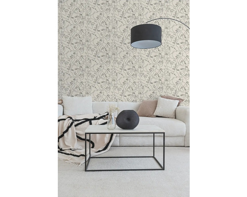 Moderne woonkamer met behang in lijntekeningstijl met gezichten, lichte corduroy bank, minimalistische salontafel en zwarte booglamp.