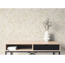 Vlies fotobehang met goudkleurig line art gezichtspatroon op een muur achter een houten consoletafel met een witte vaas.