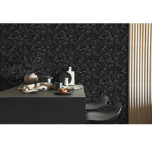 Donker behang met witte lijntekening van gezichten in een moderne keuken met een zwart kookeiland.