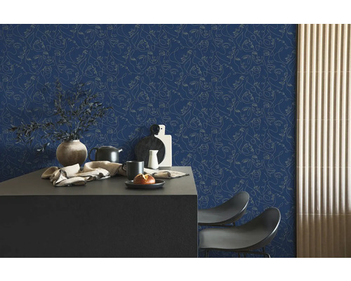 Vliesbehang met abstracte lijntekening van gezichten in een modern ingerichte kamer met donker aanrecht en houten panelen.