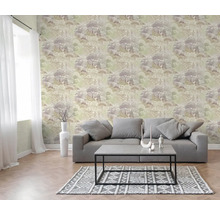 Vliesbehang met bos- en boompatroon in een lichte woonkamer met bank, salontafel en vloerkleed met geometrisch patroon.