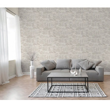 Woonkamer met vliesbehang met bosmotief, grijze bank, salontafel en vloerkleed met patroon.