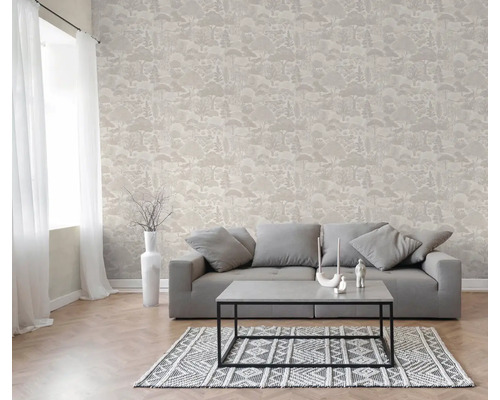 Woonkamer met vliesbehang met bosmotief, grijze bank, salontafel en vloerkleed met patroon.