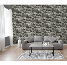 Moderne woonkamer met behang met boompatroon, grijze bank, salontafel en vloerkleed met patroon op een lichte houten vloer.