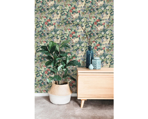 Vliesbehang met een patroon van kraanvogels en bloemen op een muur achter een dressoir en een kamerplant in een mand.