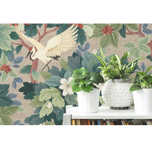 Vliesbehang met Japans kraanvogelmotief, grote groene bladeren en rode bessen achter kamerplanten op een witte plank.