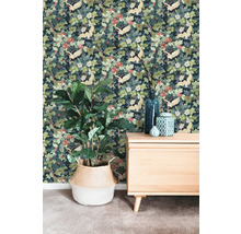 Vliesbehang met kraanvogel- en bloemenpatroon in een kamer met houten dressoir en kamerplant in een gevlochten mand.