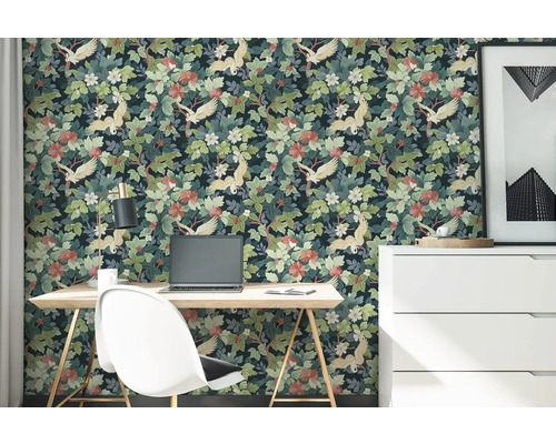 Vliesbehang met kraanvogel- en plantenpatroon in een werkkamer met bureau, stoel en ladekast.