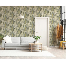 Lichte woonkamer met vliesbehang met bladpatroon, witte bank, ronde houten salontafel en een witte deur.