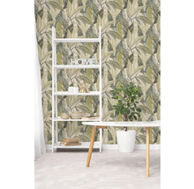 Woonruimte met patroonbehang met bladmotief, witte ladderkast, kamerplant en witte tafel.