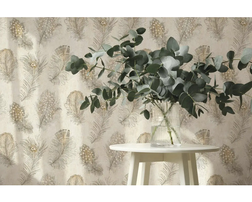 Vliesbehang met pauwenverenpatroon achter een witte tafel met eucalyptustakken in een glazen vaas.