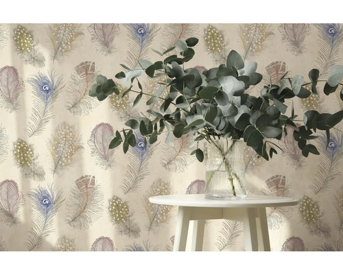 Vliesbehang met pauwenverenpatroon, daarvoor een bijzettafel met eucalyptustakken in een glazen vaas.