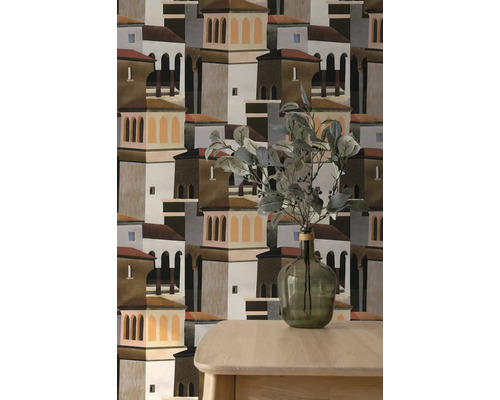 Behang met grafisch patroon van mediterrane huizen en torens, getoond achter een houten tafel en een glazen vaas met takken.