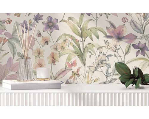 Vliesbehang met floraal patroon van grote bloemen en bladeren in aquarelstijl achter een wit dressoir met decoratie.