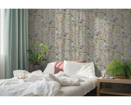 Slaapkamer met bloemig vliesbehang, wit bed met kat, kamerplanten en lichte gordijnen.