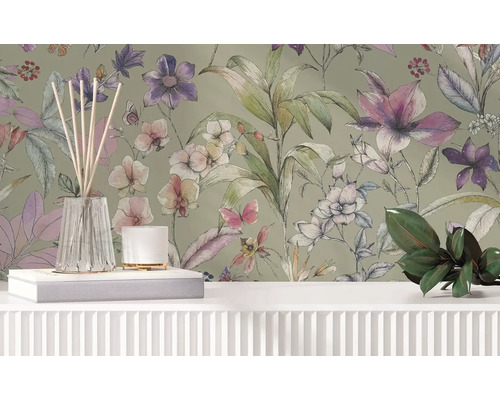 Vliesbehang met bloemig aquarelpatroon van bloemen, bladeren en vlinders achter een licht dressoir met decoratie.