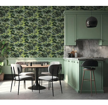 Lichte keuken en eethoek met behang met boommotief, groene kasten en een ronde houten tafel met vier stoelen.