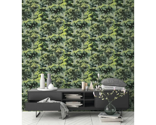 Vliesbehang met gedetailleerd bosmotief en groene bomen in een modern ingerichte woonkamer met donker dressoir en lichte vloer.