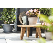 Scene met beplante bloempotten en een houten tafel op een terras