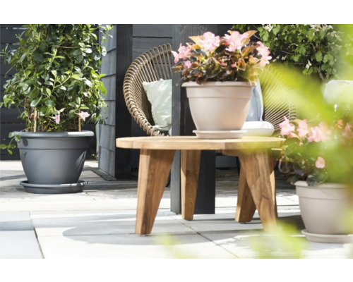 Scene met beplante bloempotten en een houten tafel op een terras