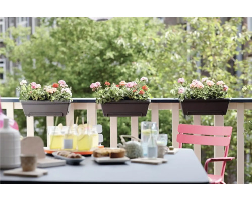 Balkonscène met bloembakken en gedekte tafel