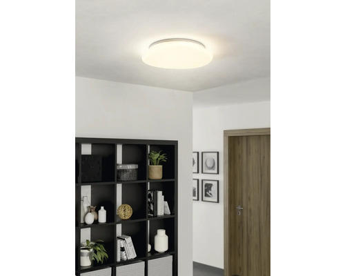 Plafondlamp in een lichte kamer met boekenkast en deur