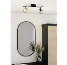 Plafondlamp met twee spots en ovale spiegel boven ladekast