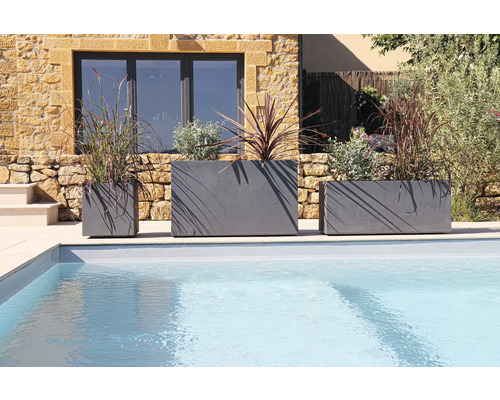 Drie beplante plantenbakken van verschillende grootte naast een zwembad.