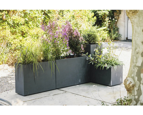 Metalen plantenbakken met verschillende planten buitenshuis